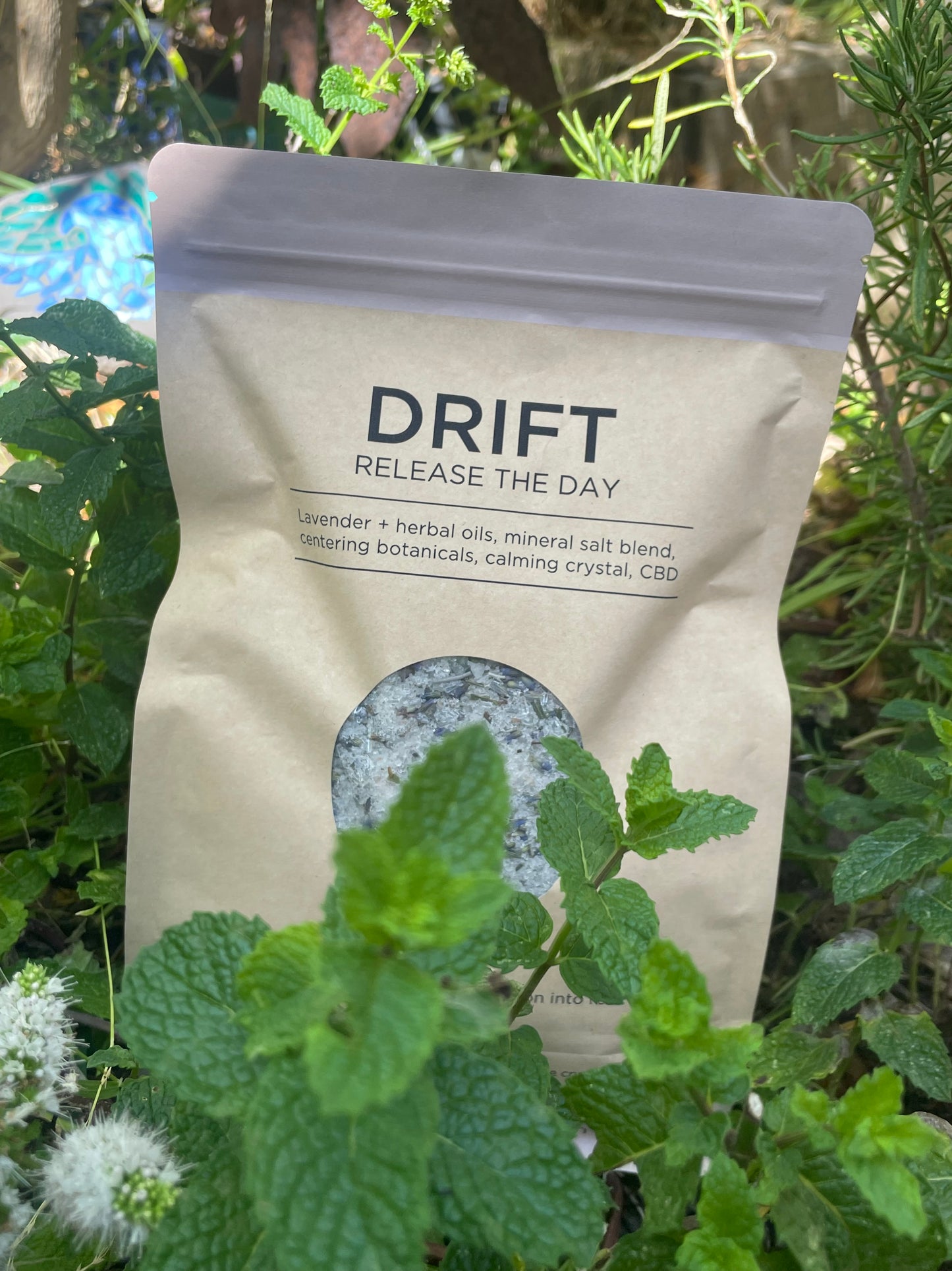 DRIFT: Release The Day – Soul Soaks bath blend in kraft pouch surrounded by fresh herbs