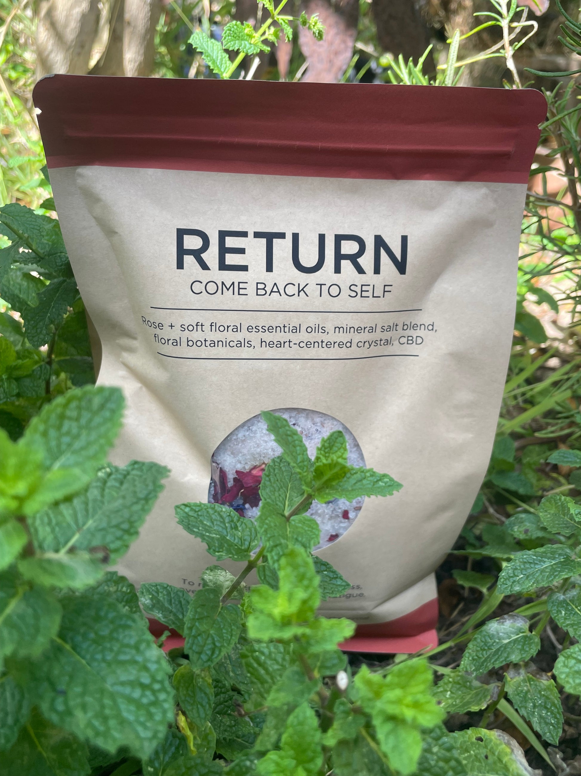 RETURN: Come Back To Self – Soul Soaks floral mineral bath blend in kraft pouch among fresh herbs